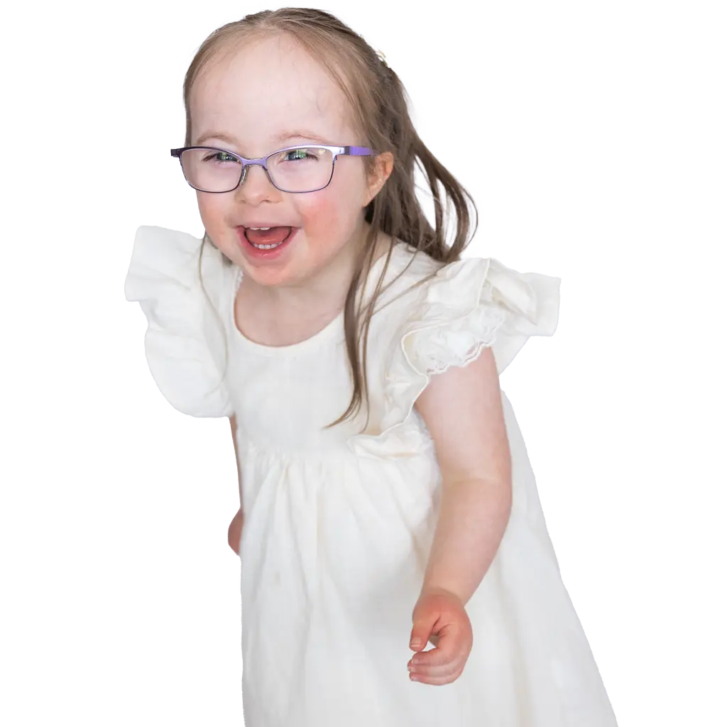A little girl named Claire with purple glasses smiles at the camera with her arm outstretched.